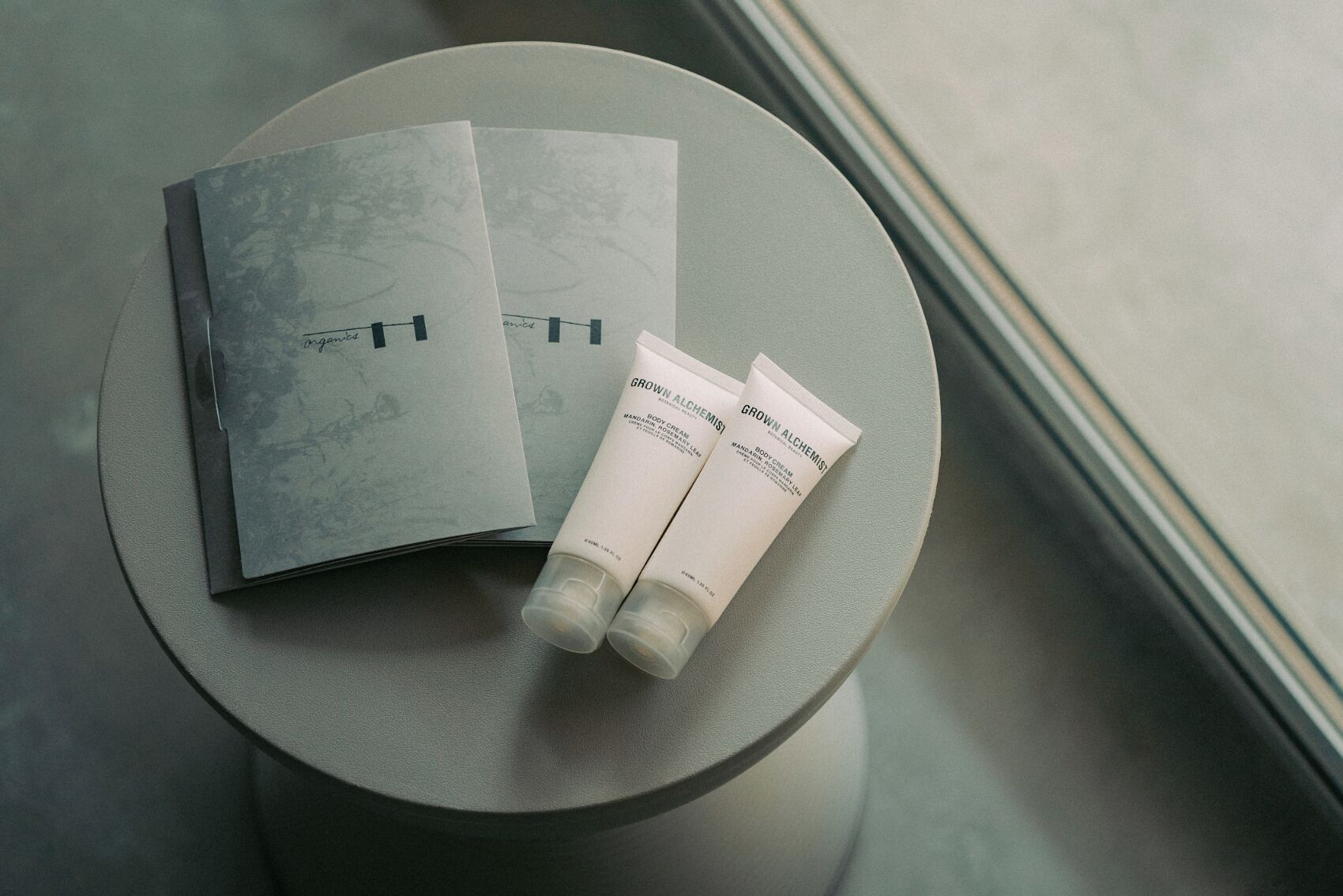 A table with a book and two tubes of body cream.