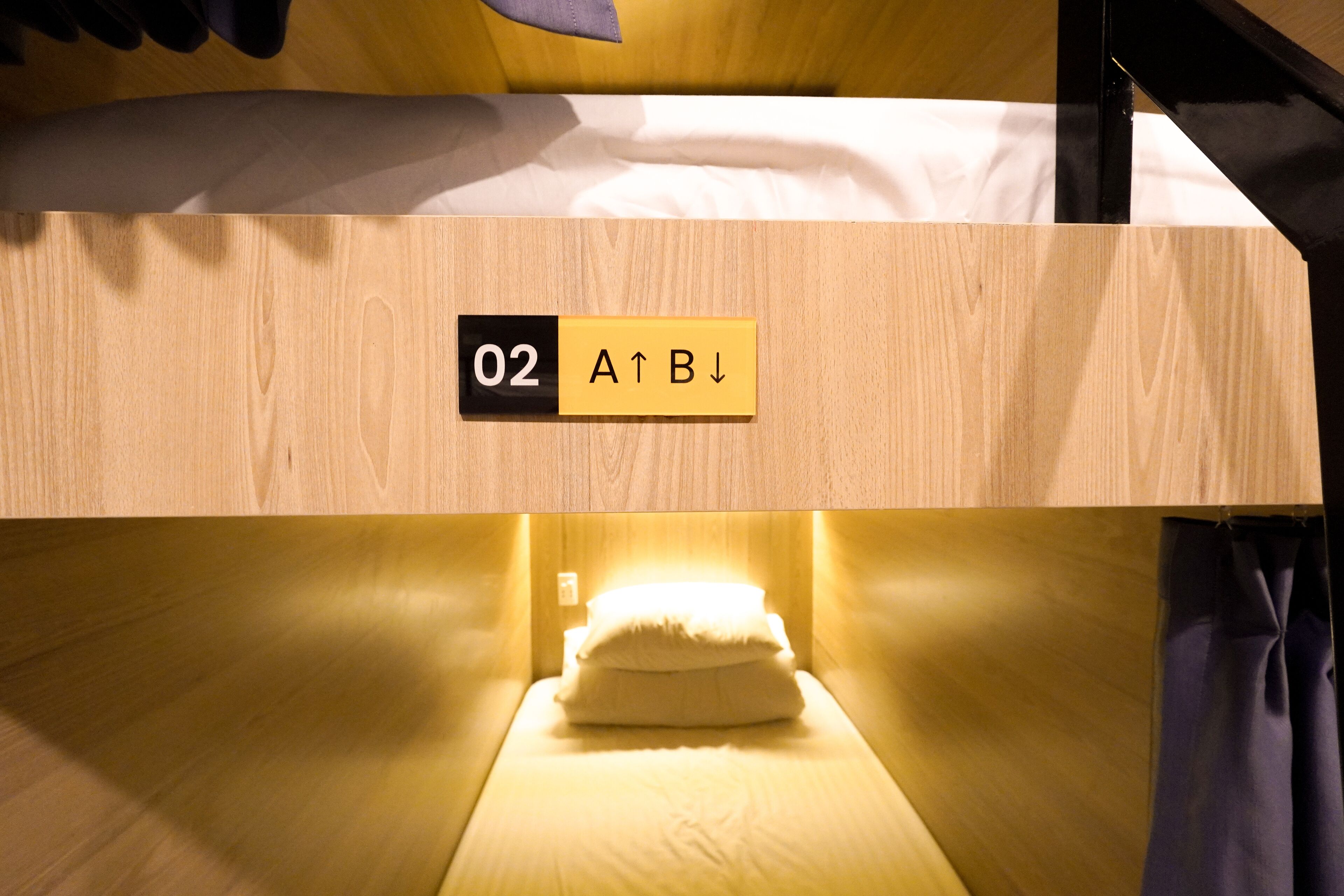 A bunk bed with a sign indicating room number 02 and directional arrows.
