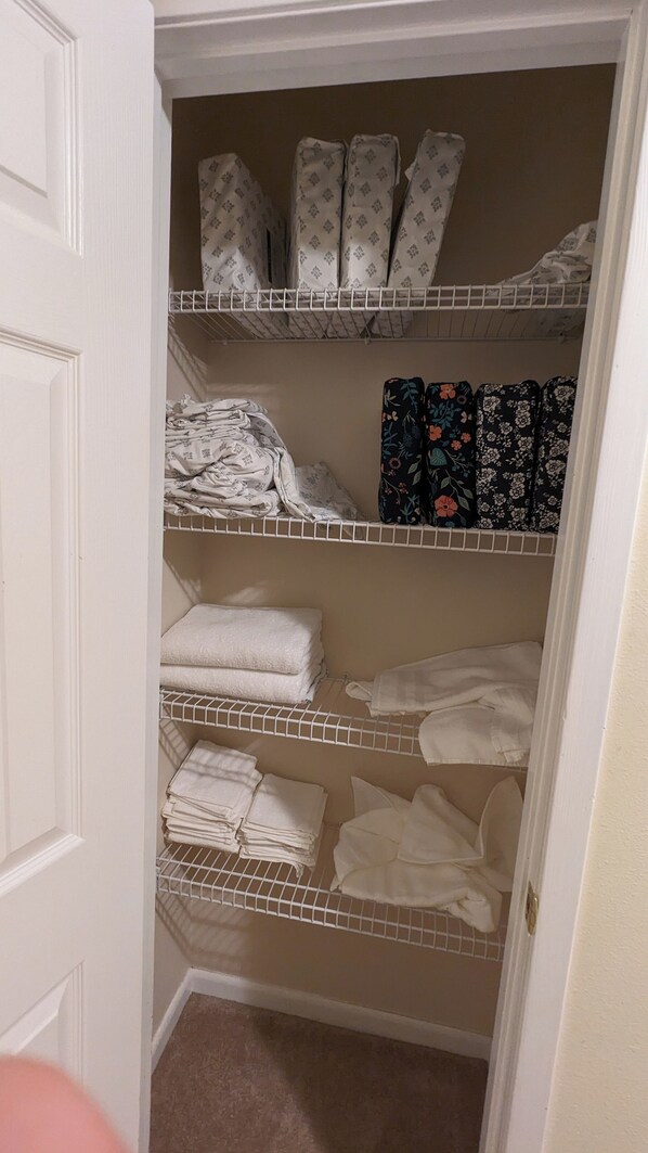 A closet with multiple shelves holding folded towels and patterned linens. - Gulf Coast Getaway Home-3 bed, 7m walk to bay beach and pier (Mary Esther)