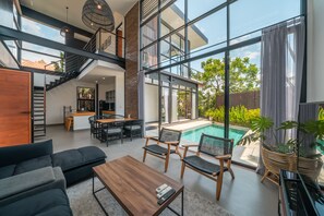 A modern interior with a staircase, dining area, and a pool. - Villa Greta  (Canggu)