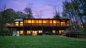 A two-story wooden cabin with a deck and a covered patio area. - Heartland Lodge: Multi-fam cabin in Hocking Hills (Logan)