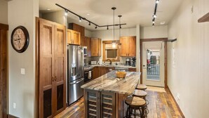 Una cocina moderna con armarios de madera, electrodomésticos de acero inoxidable y encimera de mármol.