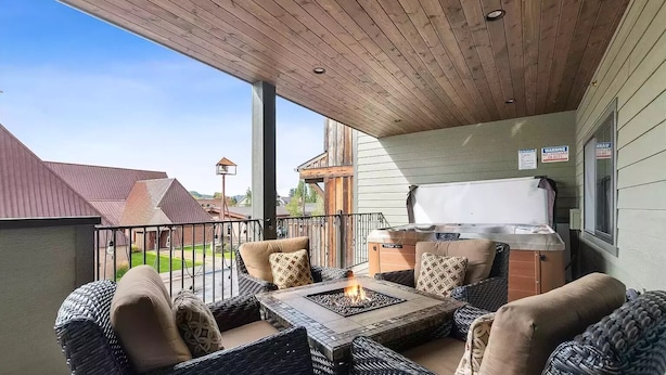Un espacio de descanso al aire libre con mobiliario de mimbre y una chimenea.