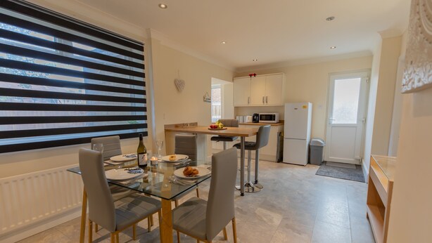A modern kitchen with white cabinets, a microwave, and a refrigerator. - 3bed House in Stockton-on-tees- Free Wifi, Parking (Stockton-on-Tees)