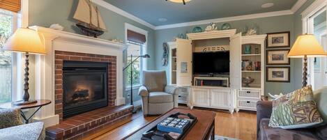 A living room with a fireplace, a television, and a bookshelf.