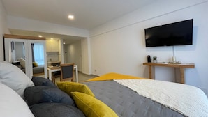 A modern bedroom with a bed, a desk, a chair, a TV, and a mirror. - Modern & Cozy Studio in San Telmo No7155 (Buenos Aires)