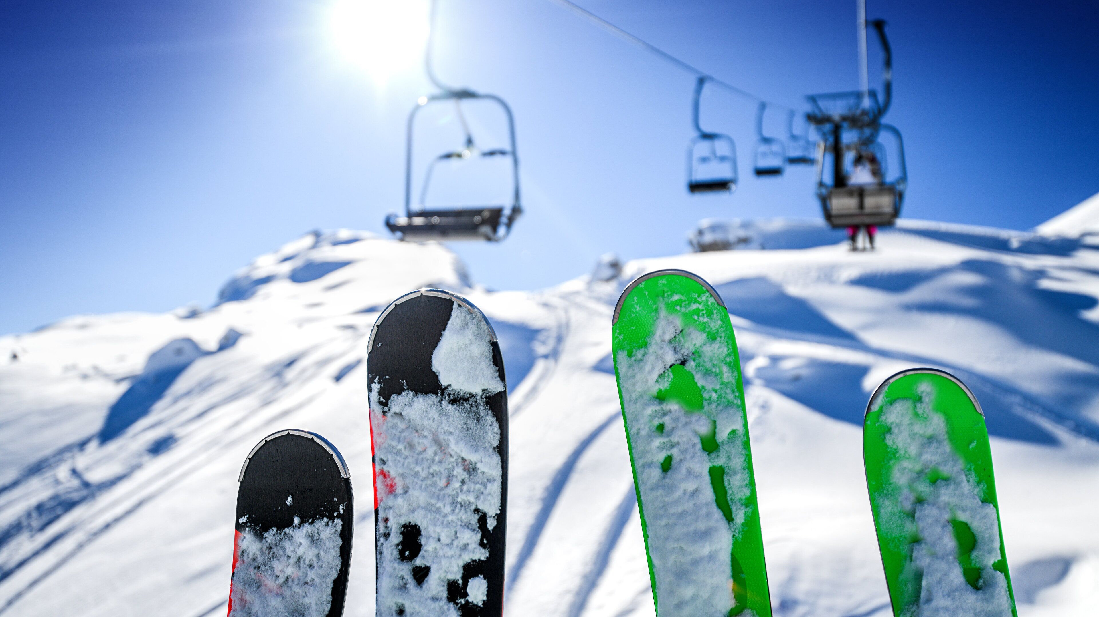 A ski lift with chairs and a snowy slope.
