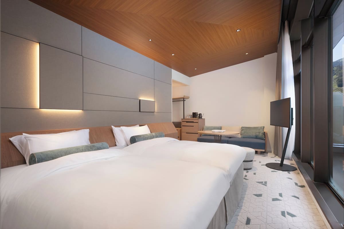 Ein modernes Hotelzimmer mit einem großen Bett, einem Schreibtisch und einer Couch.