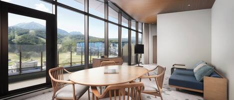 A modern room with a large window, a round wooden table, and a sofa.