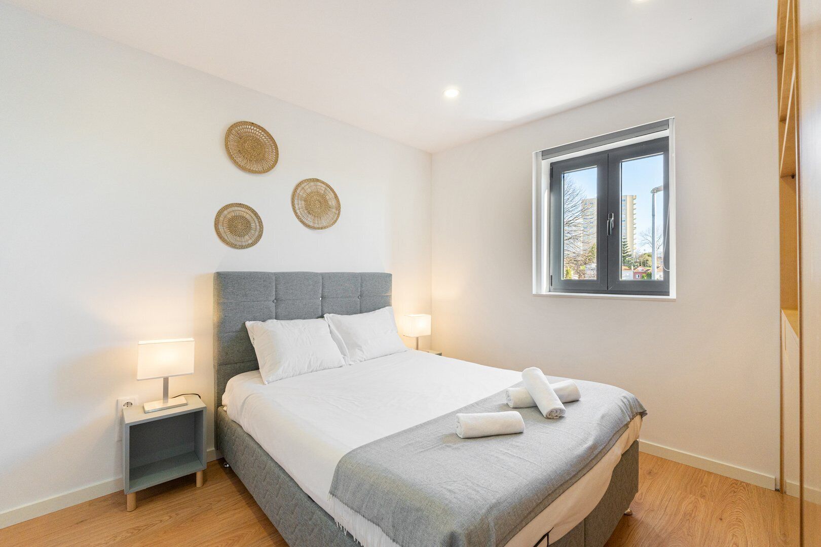 Une chambre à coucher avec un lit, des tables de chevet et une fenêtre.