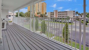 Ein Balkon mit Blick auf einen Parkplatz und Gebäude.