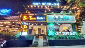 A hotel entrance with signage for 'Bai Tuo Hotel' and 'Ice Cream Tea Coffee'. - Front Beach Hotel  (Ho Chi Minh City)