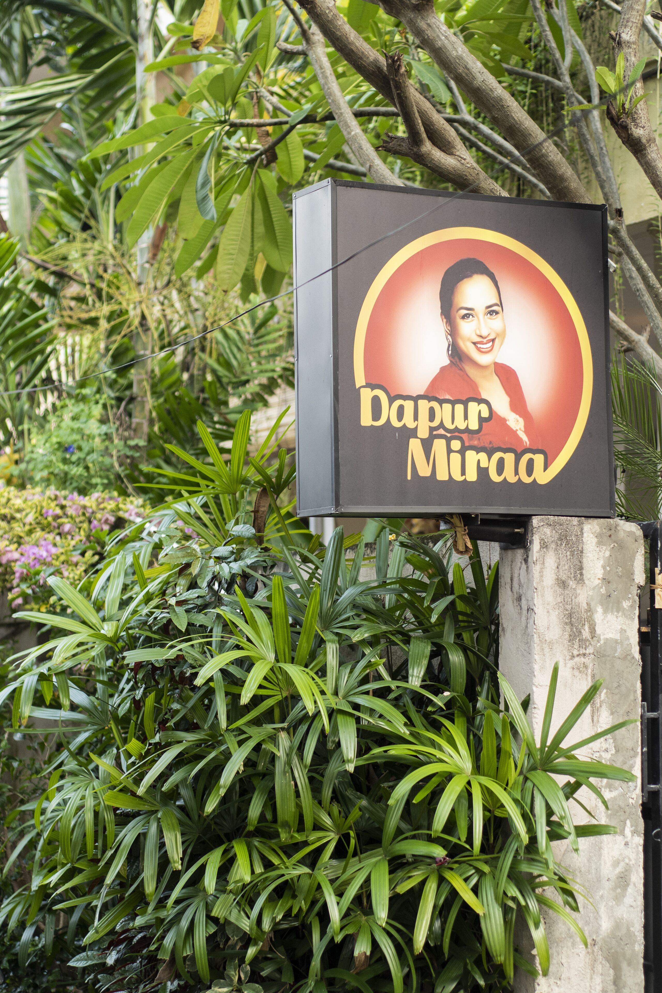 Un letrero con un diseño circular y el texto 'Dapur Miraa'.