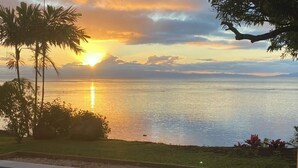 Ein Pool mit Blick auf das Meer und den Sonnenuntergang.