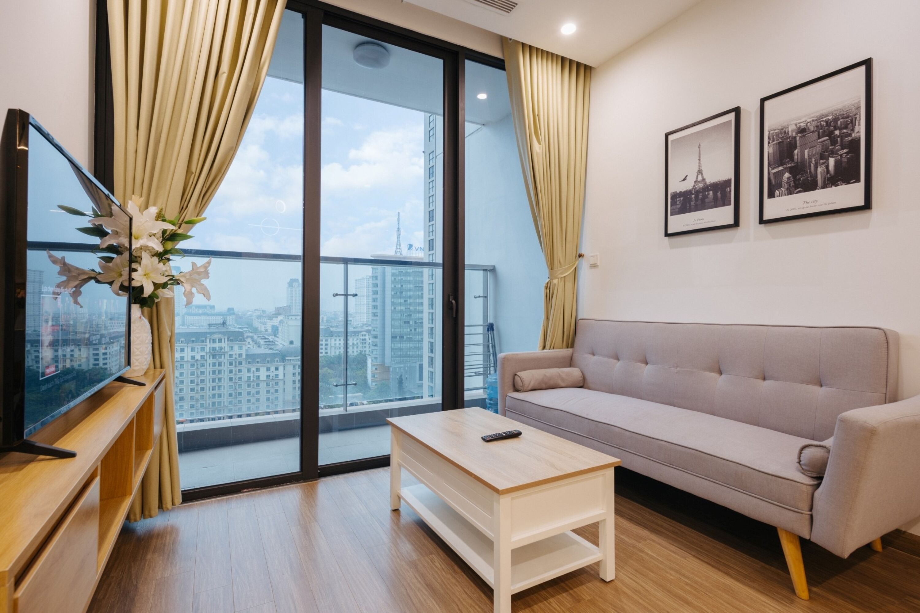 A modern living room with a sofa, a coffee table, and a TV on a wooden stand.