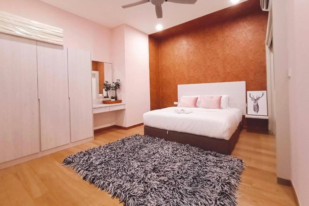 Ein Schlafzimmer mit einem Bett, einem Deckenventilator, einer Wandpaneele aus Holz, einem Teppich und einem Spiegel.
