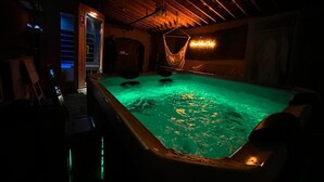 A dimly lit indoor swimming pool with a wooden ceiling and a neon sign in the background. - The Mara Waterfront Cottage, Muskoka
 (Huntsville)