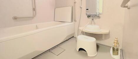 A modern bathroom with a bathtub, a small sink, and a toilet.