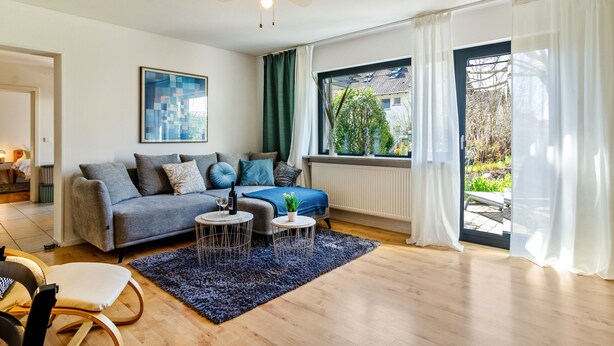Een moderne woonkamer met een bank, salontafel en uitzicht op het omliggende landschap.