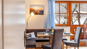 Un espace repas comprenant une table en bois, des chaises et un banc.