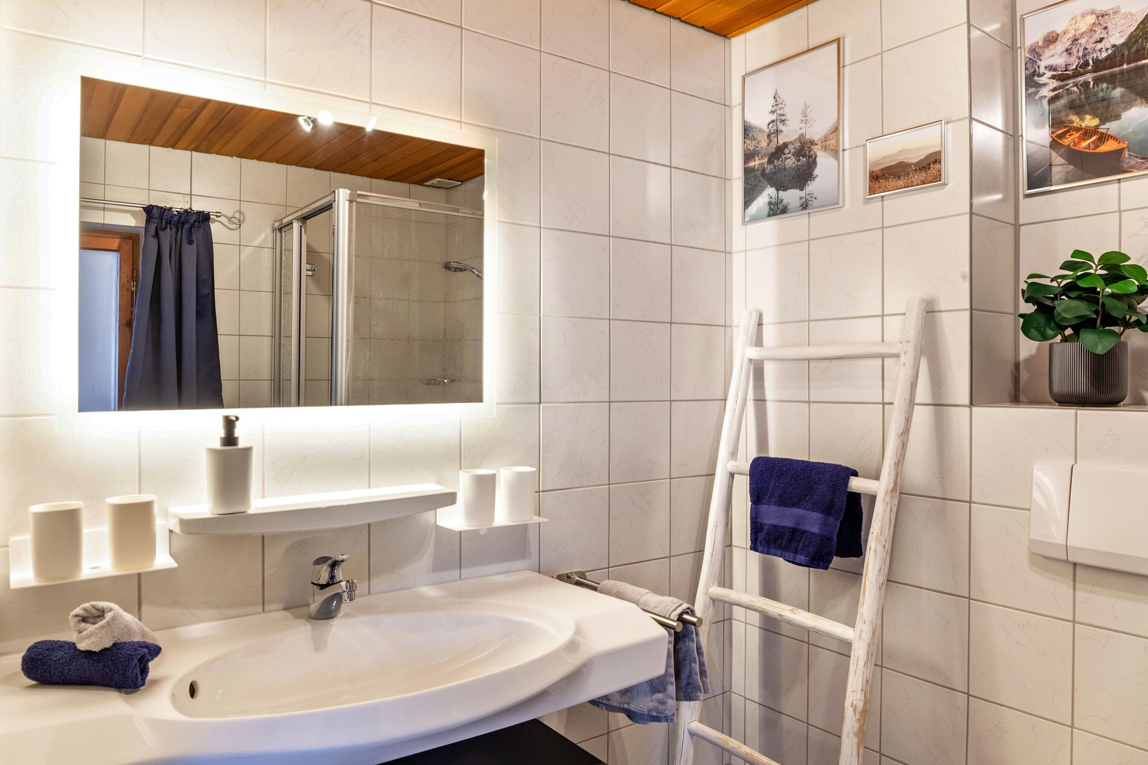 Ein Badezimmer mit Waschbecken, Spiegel und Fliesen.