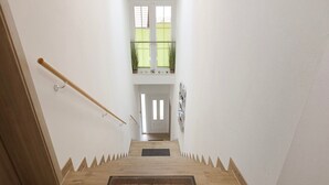 A wooden staircase with a doormat reading 'WELCOME HOME' leading to a door. - Apartment 'Ferienwohnung Gauchach' with Shared Garden, Balcony and Wi-Fi (Löffingen)