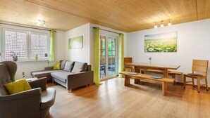 Una sala de estar moderna con sofá, sillón, mesa de madera y banco.