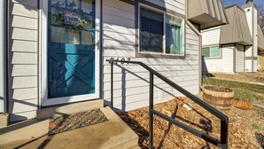 A house with a blue door, a welcome mat, and a number '8107' on the door.