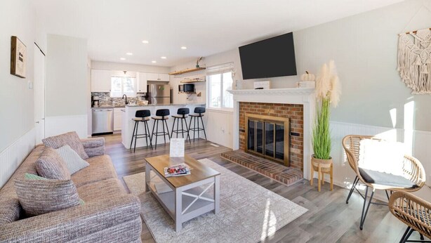 A modern living room with a sofa, coffee table, and a fireplace.