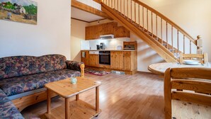 A living room with a sofa, a wooden coffee table, and a staircase leading to an upper floor.