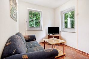 A living room with a sofa, a TV, and a table. - Apartment "Haus Seeadler 8" with Shared Terrace & Wi-Fi (Koserow)