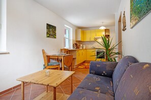 Un espace de vie compact comprenant un coin repas, une kitchenette et un canapé.