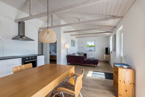 Eine moderne Küche mit einem Holzespeisetisch, Stühlen und einer Pendelleuchte.