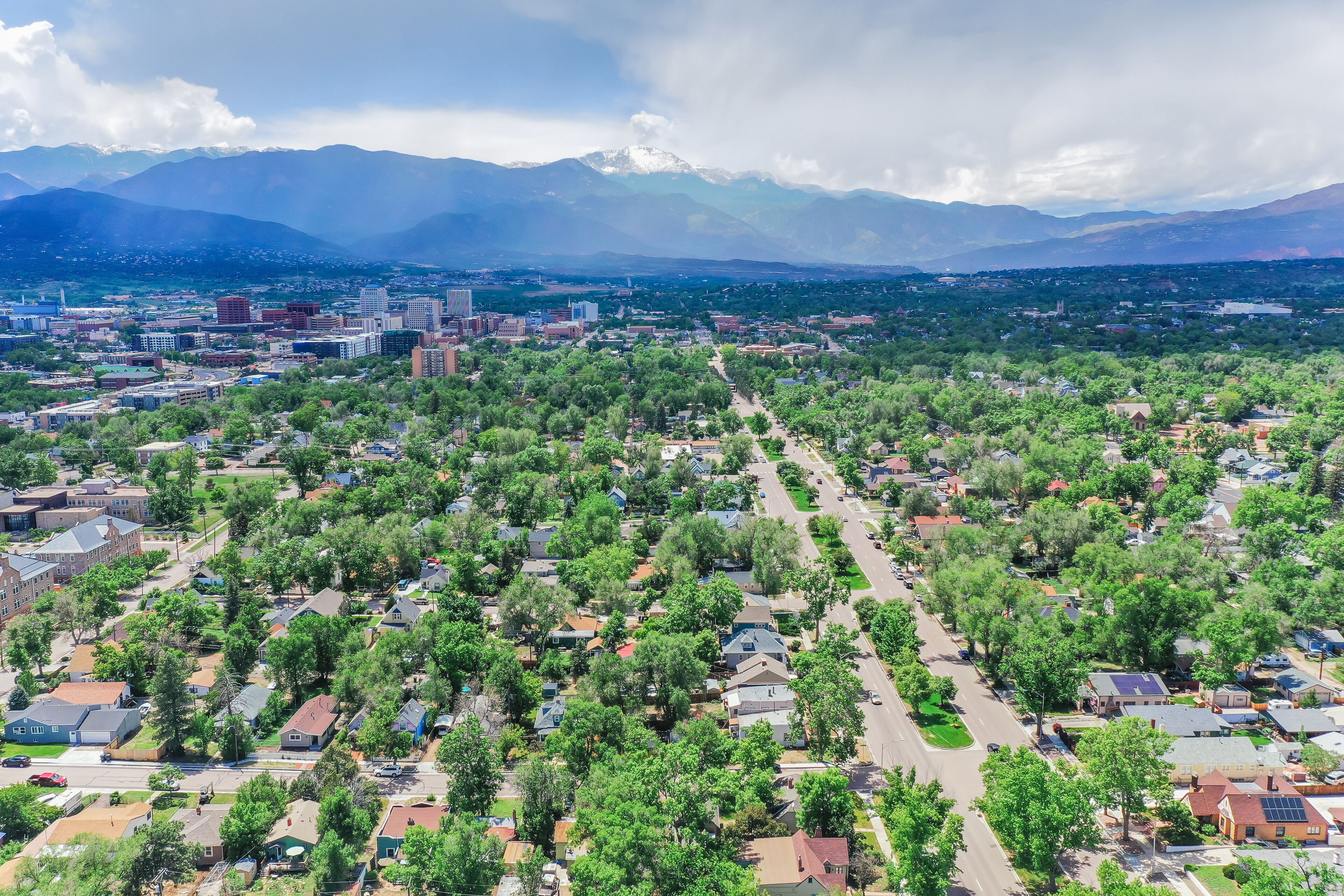 Vista aérea de uma área residencial com casas, ruas e montanhas ao longe.