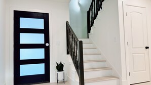A staircase with a black railing and white walls.