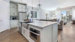 Een moderne keuken met witte kasten, roestvrijstalen apparatuur en een centraal eiland.