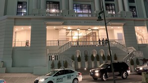 Un edificio de estilo arquitectónico clásico, con una entrada imponente con columnas y un reloj.