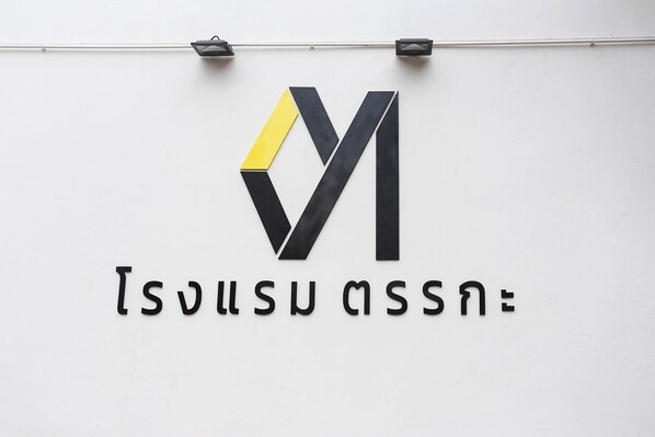 A logo with a geometric design and Thai text below it.