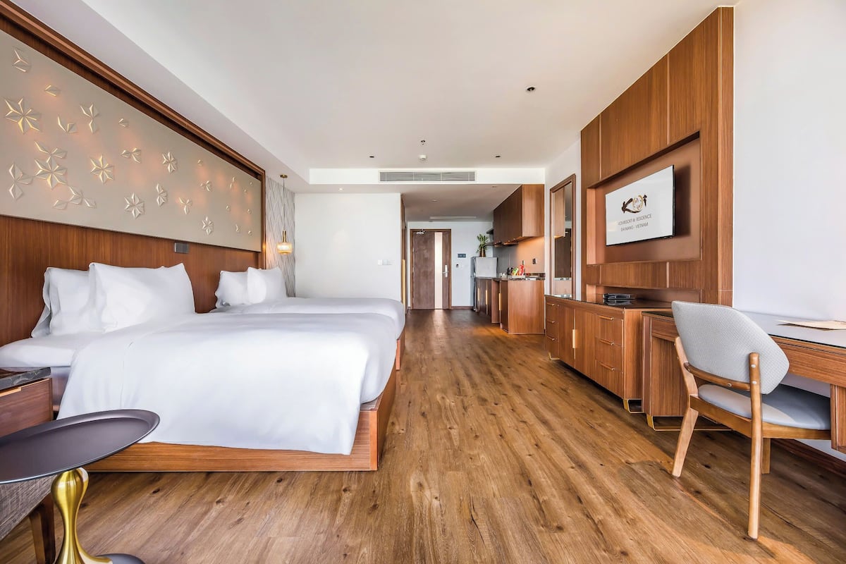 Une chambre d’hôtel moderne, dotée d’un grand lit, d’un bureau et d’une télévision.