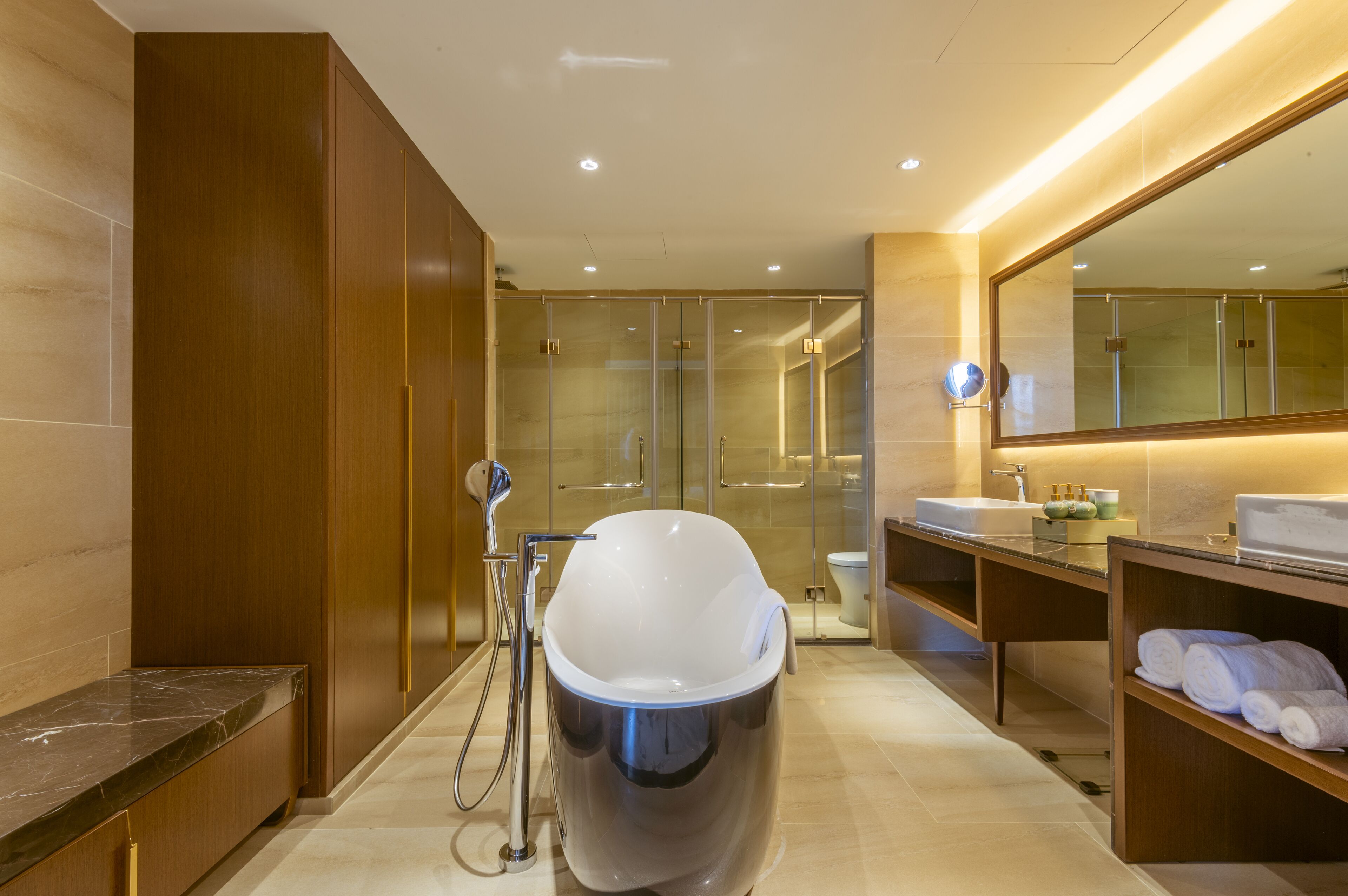 A modern bathroom with a freestanding bathtub, a glass-enclosed shower, and a vanity with a mirror.