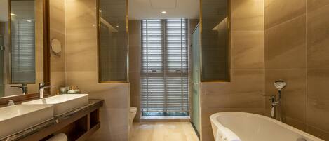 Un baño moderno con una bañera grande, dos lavamanos y un mueble tocador con espejo.