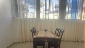 Een eetruimte met een rechthoekige tafel en zes stoelen.