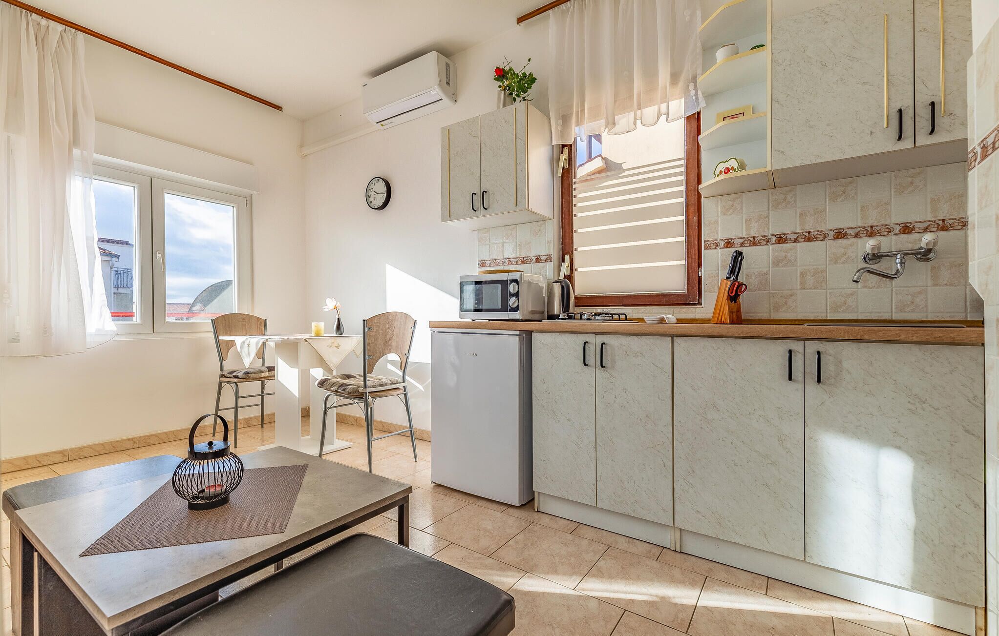 A modern kitchen with a dining area, featuring a microwave, toaster, and a small refrigerator.