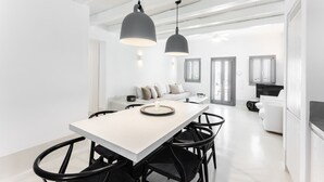 Une cuisine moderne dotée d’un îlot central, de chaises noires et de luminaires suspendus.