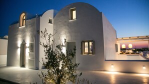 Un bâtiment moderne doté d’une façade incurvée, d’une petite fenêtre et d’une porte.