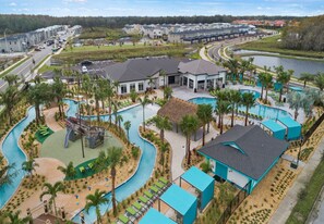 A resort with a swimming pool, a water slide, and a boat ramp.
