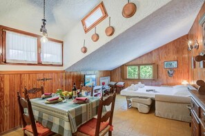 A cozy room with a dining table set for two, a bed, and a television. - The Secret Garden in the City Center (Bardonecchia)