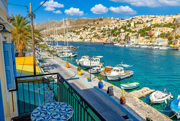 Une ville côtière dotée d’un port de plaisance, de bâtiments et d’un ciel bleu dégagé.