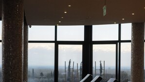 A row of lounge chairs with towels, large windows, and a view of a mountainous landscape. - Panorama Kakheti Resort (Gurjaani)