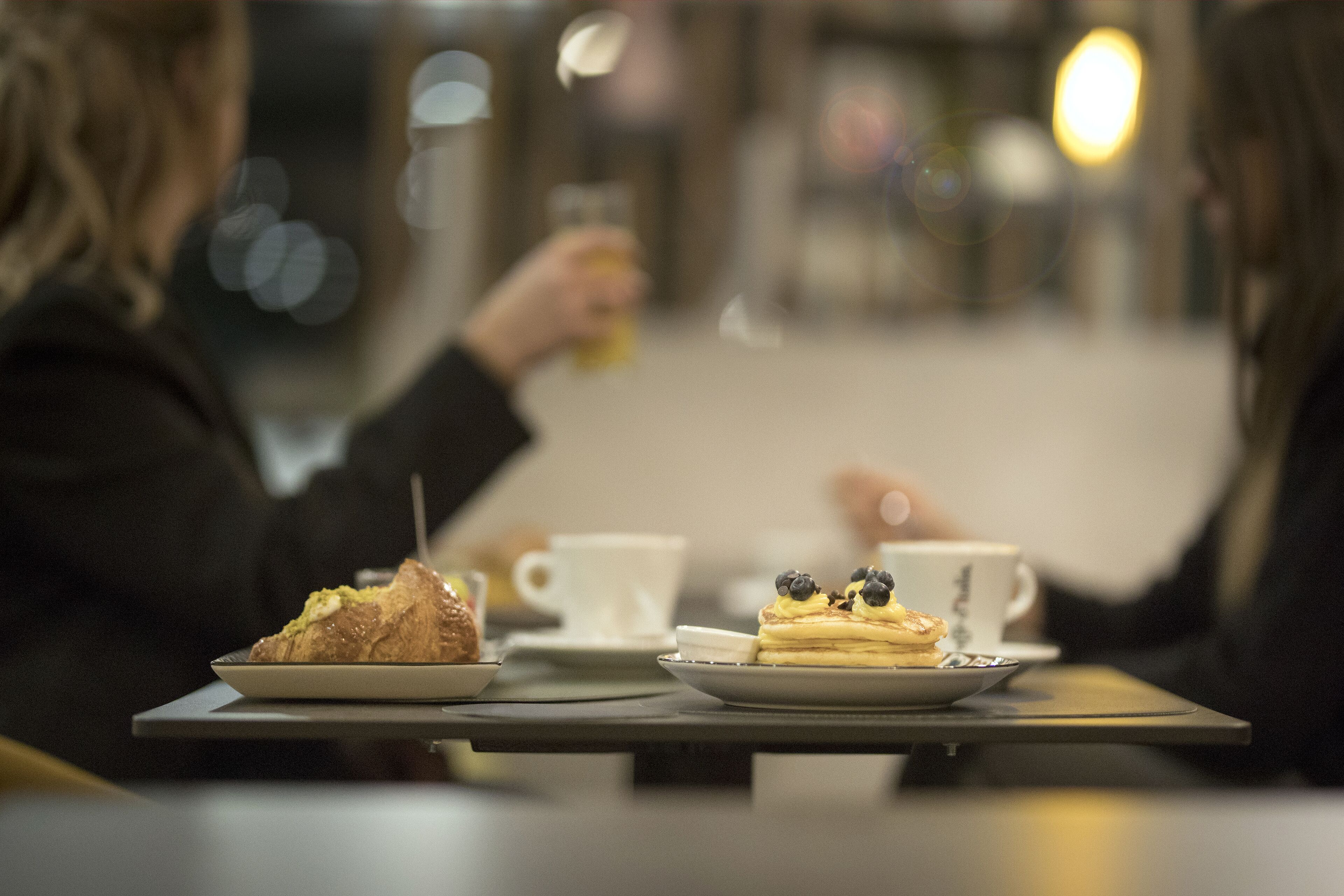Una mesa con dos platos de comida y dos tazas blancas.